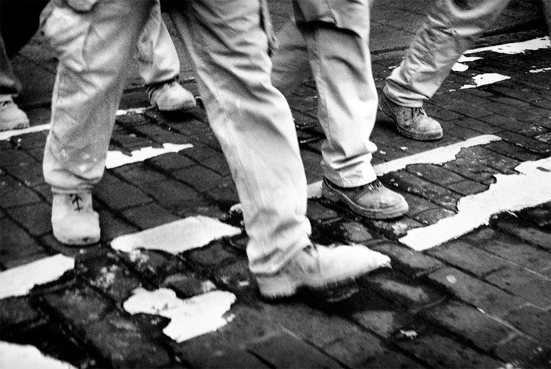 Legs and shoes on striped paving.